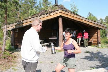 Aud Lillegård serverer kaffe til Kåre Moe ved gapahuke n ved Storvatnet