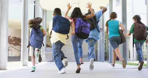 Glade barn løper i gangen på skolen
