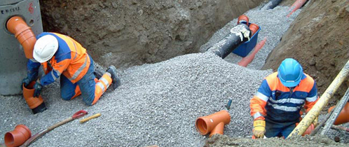 Arbeidere jobber med rør under jorda. Arbeidere jobber med rør under jorda.