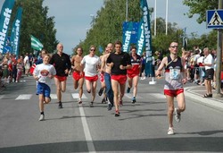 Henrik Grøset i mål i Østersund, med en hale av glade RT-løpere etter seg.