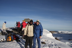 Utsikten fra toppen av Afrikas høyeste fjell er ikke mye å skryte av der den ligger ved et nærmest paddeflatt, stort krater. Her er Koffertløperen på Uhuru Peak sammen med David, en av guidene som etterpå overtok koffertløperens sko og genser.