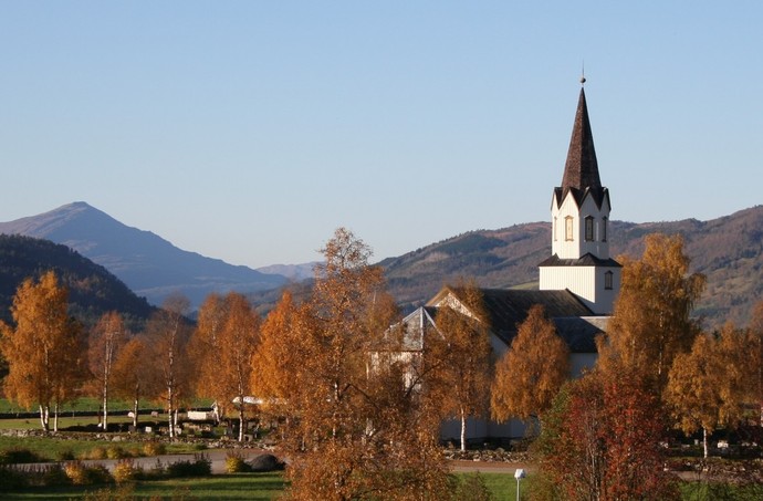 Rindal kirke i h%F8stfarger og med Knyken i bakgrunnen_1024x673