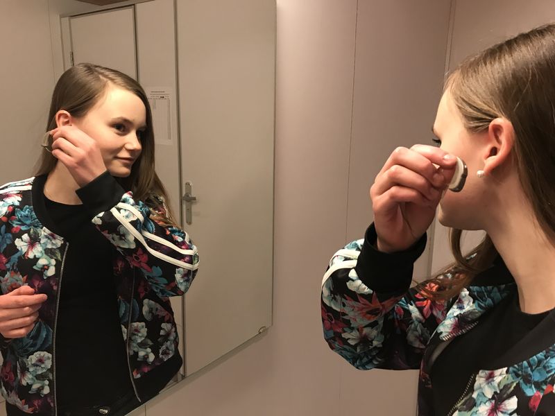 Linnea Fagermoen Apeland tar på seg høreapparatet