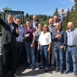 Gruppe mennesker foran en traktor