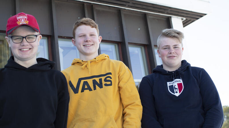 Tre gutter foran et skolebygg
