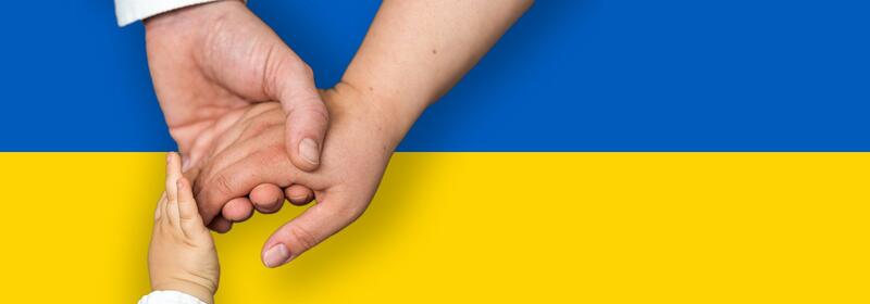 Det ukrainske flagget og voksne og barn som holder hender