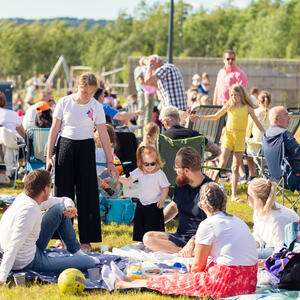Foto av folk som sitter på gresset i parken