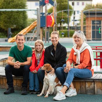 Foto av en familie som valgte å flytte til Brumunddal foran lekeparken i Broparken