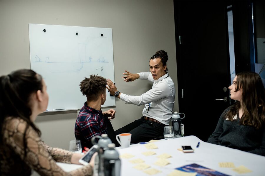 Isak tegner en enkel skisse av hvordan de gjenbruker matavfall som energi i hans mors hjemland Tanzania. 