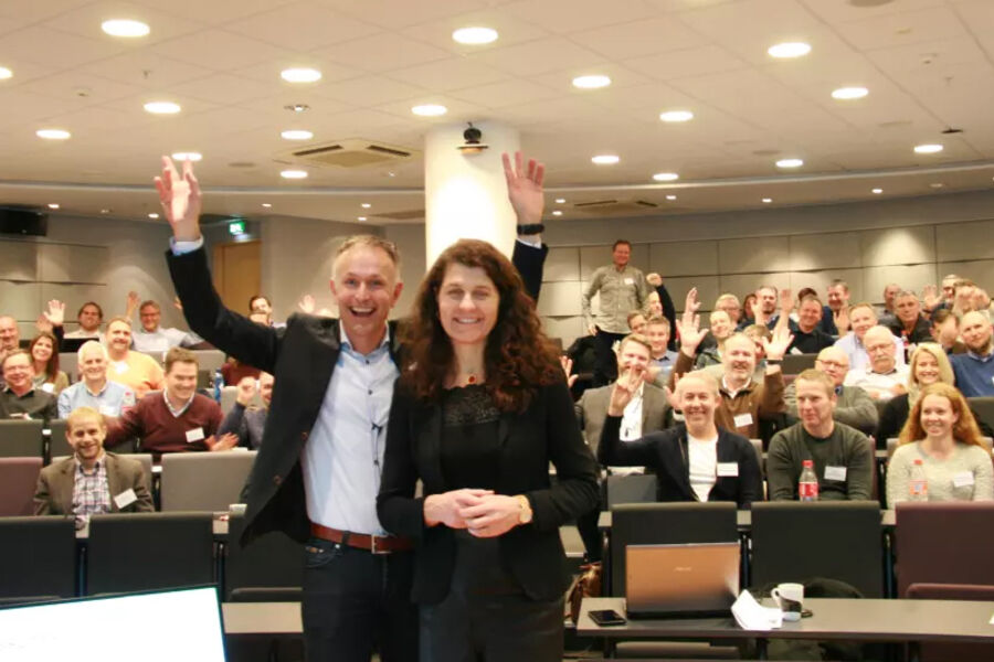 Katharina Bramslev og Kjell Petter Småge foran en forsamling glade deltagere.