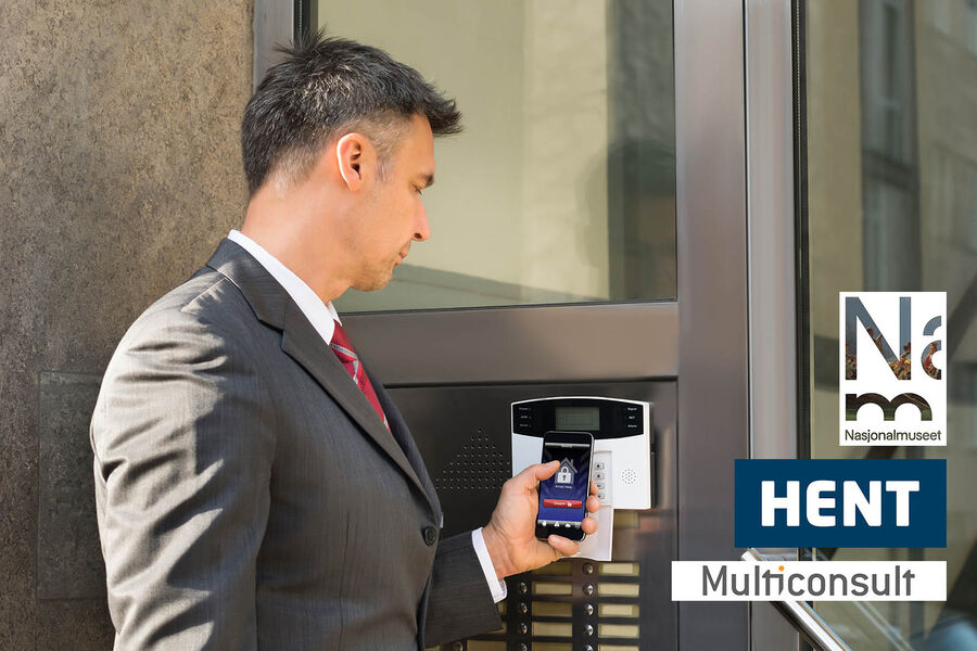 Mature Businessman Holding Smartphone For Disarming Security System Of Door