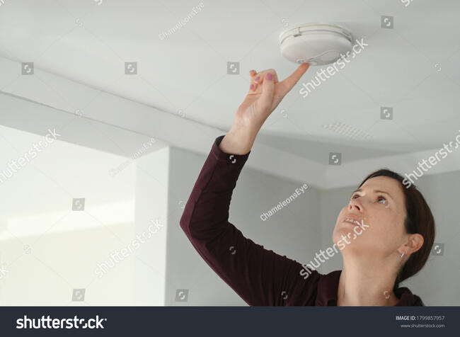 stock-photo-young-adult-woman-female-age-checking-smoke-detector-fire-alarm-appliance-device-at-home-1799857957
