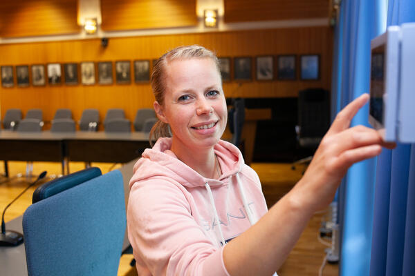 FUNGERER. I kommunestyresalen i Jevnaker kommune i Viken har det i mange år vært god lyd for alle takket være teleslynge. Varaordfører Kristine Belsby konstaterer at teleslyngen fungerer som den skal. Foto. Siv Storløkken, Jevnaker kommune.