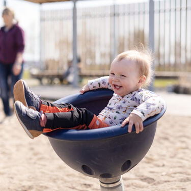 Foto av barn som snurrer på en leke i Mjøsparken