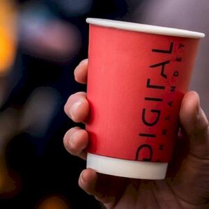 rød papp kaffekopp som holdes i en hånd