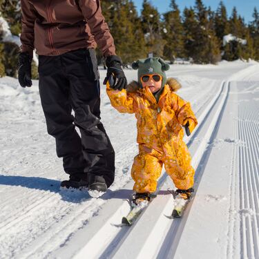 Foto av barn som går på ski og leier moren sin