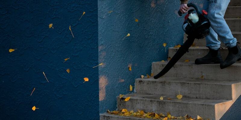 Vaktmestertjeneste for borettslag og sameier i Oslo, illustrert ved en mann som blåser løv ned en trapp.