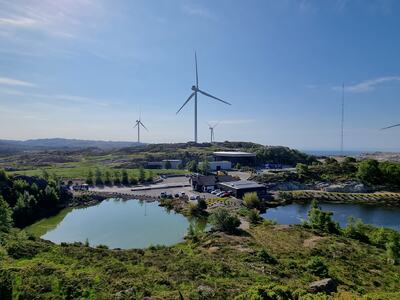 Kontorbygget på Svåheia, omkranset av små vann, grønn natur og vindmøller.