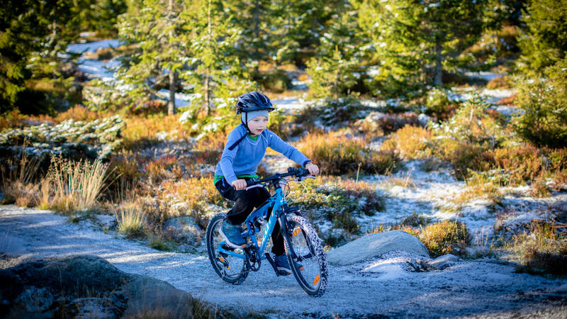 Foto av barn på sykkel i fjellet