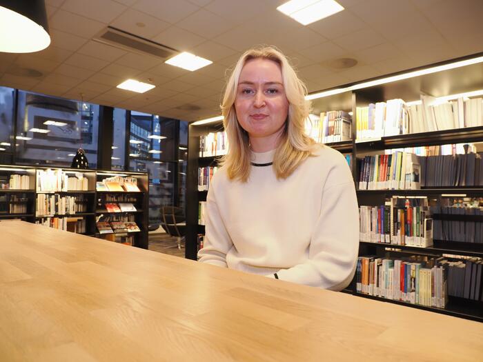 Martine Therece Værlien ved bord på biblioteket på Campus Drammen, USN