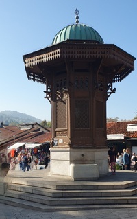 The iconic Sebilj, an Ottoman-style wooden fountain (sebil) fountain, stands proudly in the heart of Sarajevo`s historic Bascarsija Square