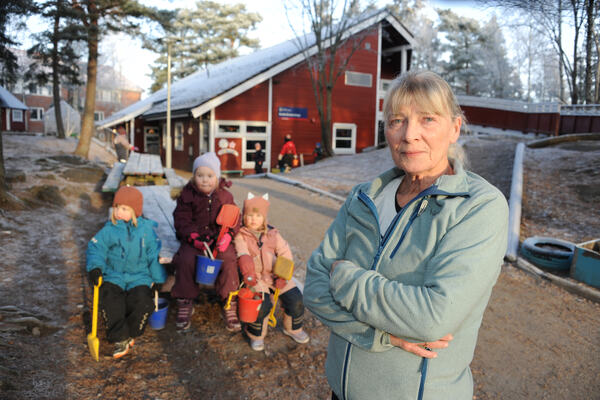 Bilde av dame i barnehage med tre barnehagebarn i bakgrunnen