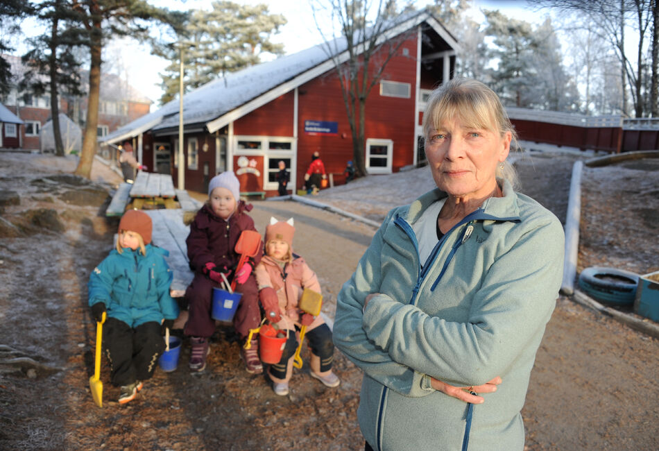 Bilde av dame i barnehage med tre barnehagebarn i bakgrunnen