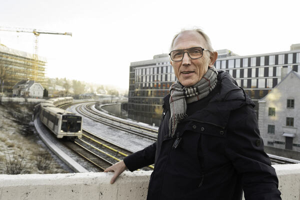 ENGASJERT. Tormod Karlsen har flere verv i Hørselshemmedes Landsforbund og vil gjerne kjempe videre for medlemmene. Et langt arbeidsliv med mye støy ødela hans egen hørsel. Mann står på bro med t-banespor i bakgrunnen