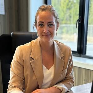 ung dame sitter ved kontorpulten bak pc