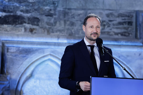 Bilde av kronprins Haakon i mørk blå dress som holder tale