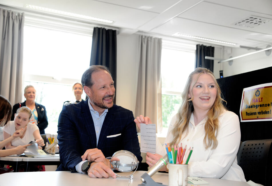 Kronprisn Haakon ler hjertelig sammen med en elev når han klarer å knekke koden