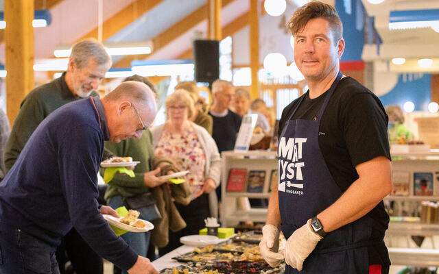 bilde av Henning Reistadbakken og kakebord på biblioteket
