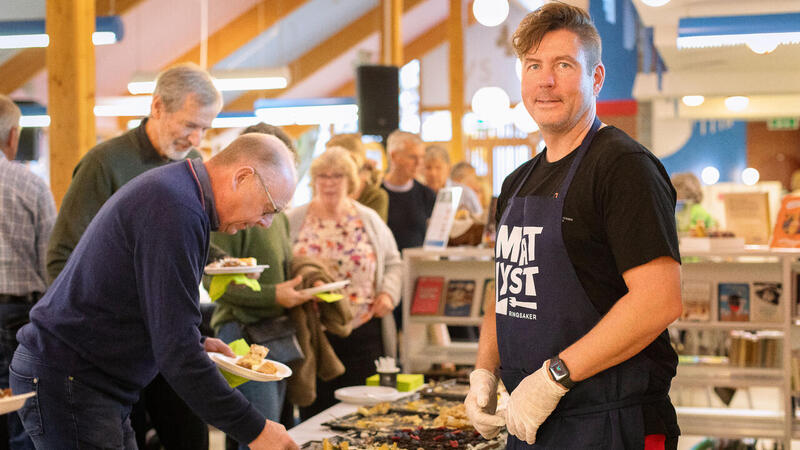 bilde av Henning Reistadbakken og kakebord på biblioteket