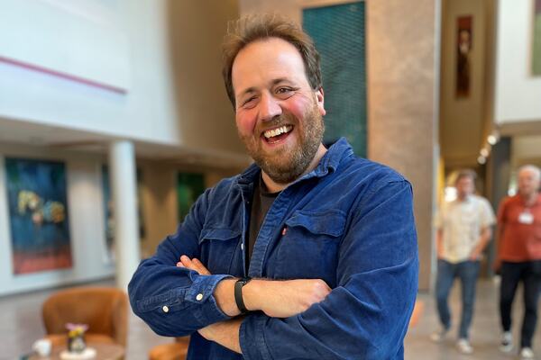 Smilende mann med skjegg og blå dongreijakke