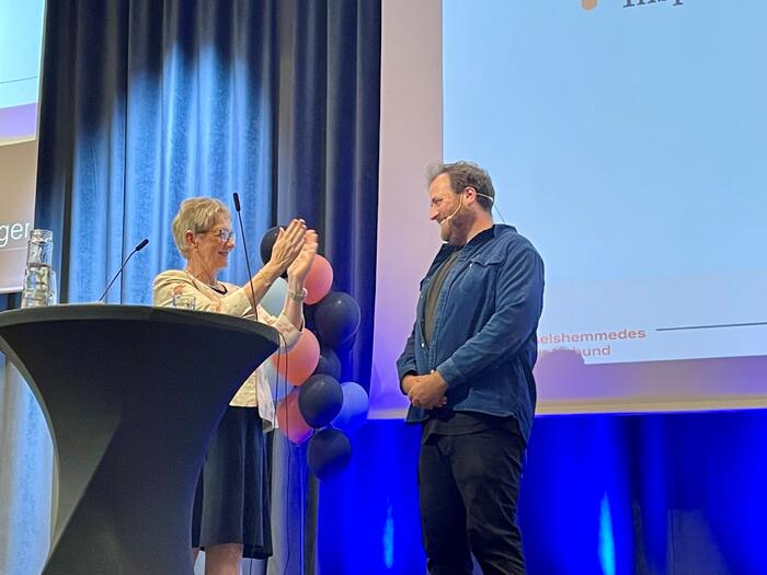 Dame klapper smilende i hendene for mann med skjegg