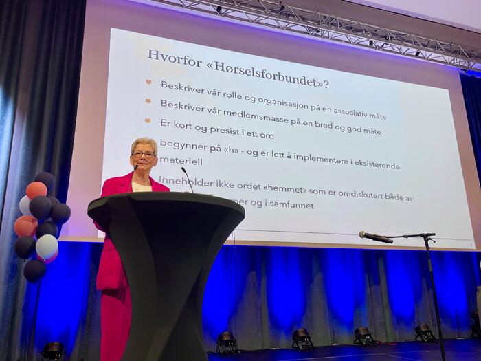 Dame i rosa dress på talestol