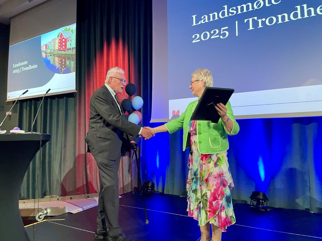 Mann tas imot på scenen av dame med diplom