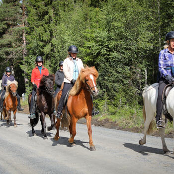 Foto av ryttere som rir på en grusvei