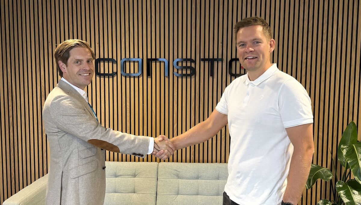 SAMARBEID Eirik Helgøy, avdelingsleder i Bravida, og Endre Kristiansen, prosjektsjef i Consto tar hverandre i hånden og smiler til kamera ved kontraktssigneringen. Foto: Consto