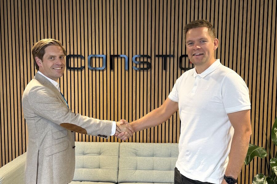 SAMARBEID Eirik Helgøy, avdelingsleder i Bravida, og Endre Kristiansen, prosjektsjef i Consto tar hverandre i hånden og smiler til kamera ved kontraktssigneringen. Foto: Consto