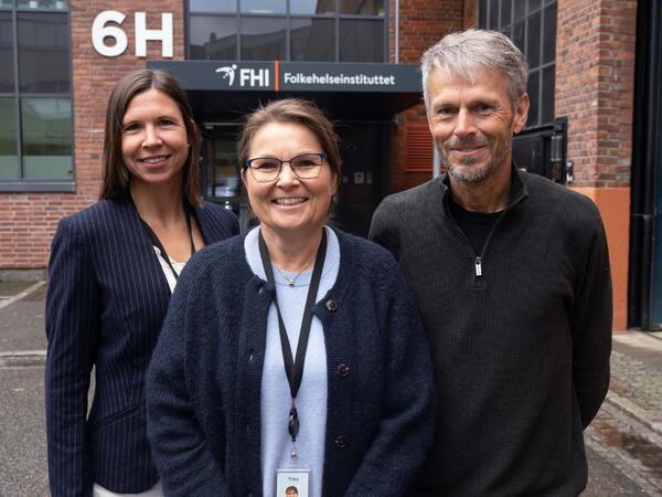 Hilde Risstad, Ingeborg Lidal og Bo Engdahl foran inngangsparti med skilt for Folkehelseinstituttet.
