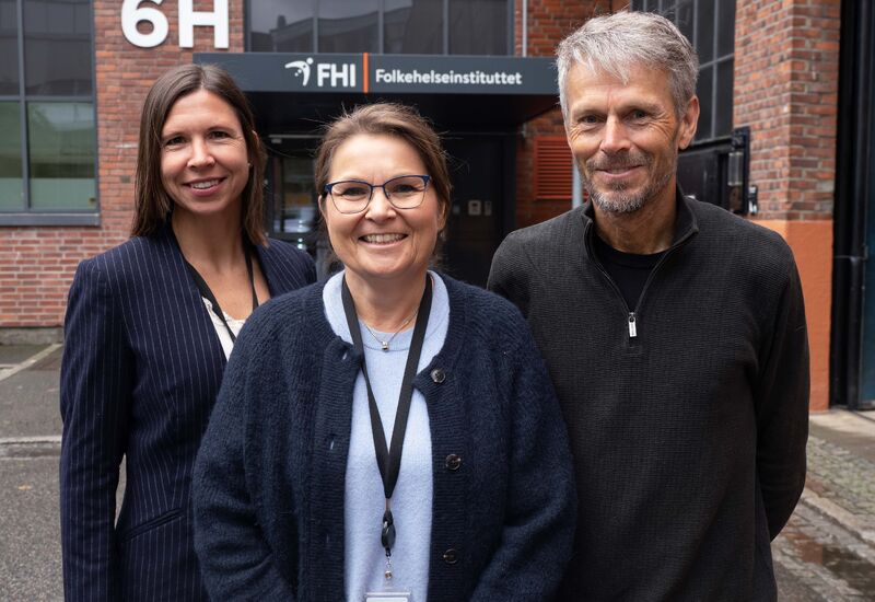 Hilde Risstad, Ingeborg Lidal og Bo Engdahl foran inngangsparti med skilt for Folkehelseinstituttet.