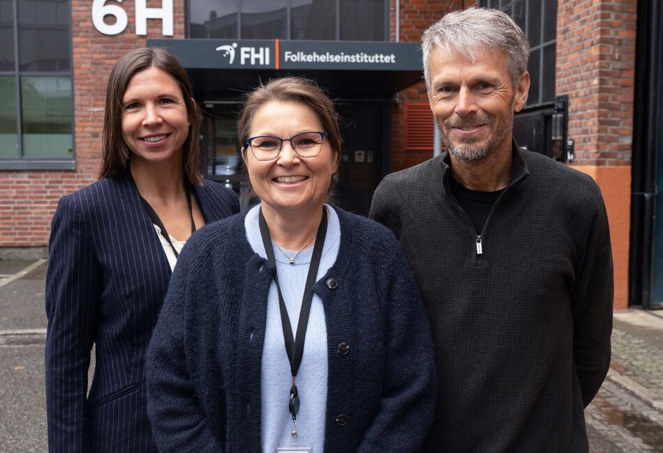 Hilde Risstad, Ingeborg Lidal og Bo Engdahl foran inngangsparti med skilt for Folkehelseinstituttet.