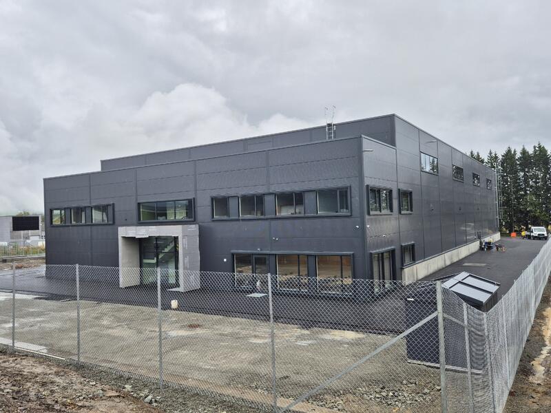 nytt grått  industribygg innrammet av gjerde