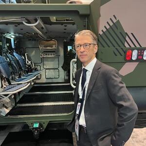 mann står foran et kjøretøy fra forsvaret