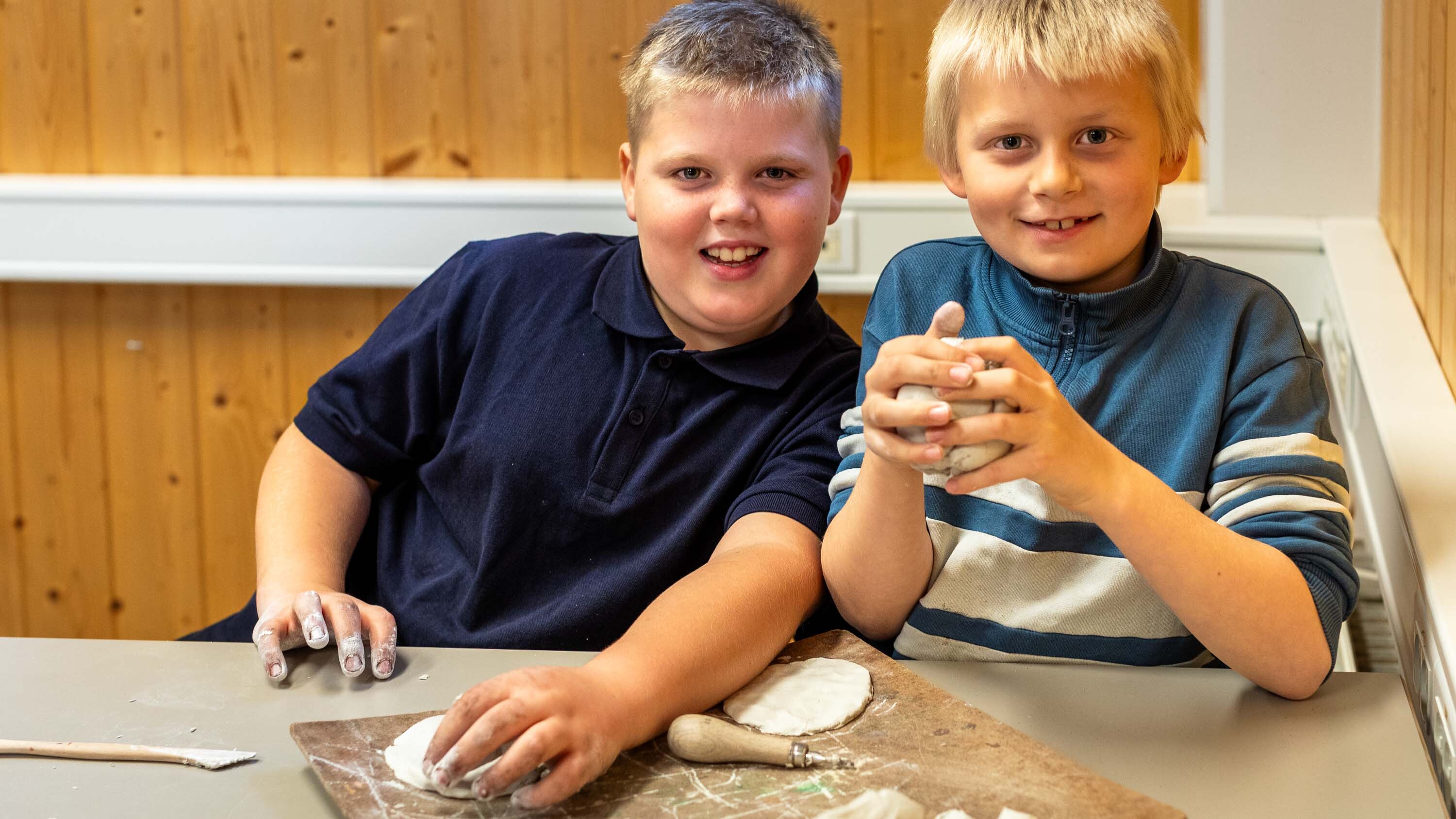 Foto av to gutter som driver med keramikk