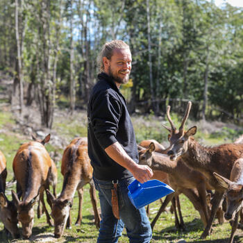 Foto av Peder Bolstad som mater hjortedyra