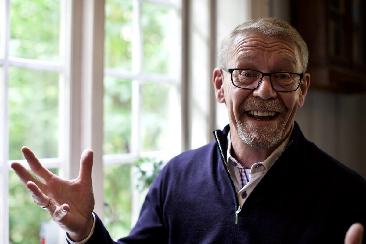 Leende mann med gestikulerende hender