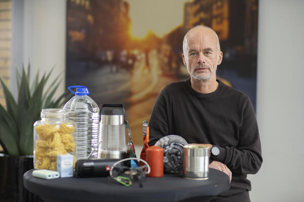 Tore Kamfjord viser frem vann, nødlader, hermetikk og andre varer som er viktige å ha i et beredskapslager.