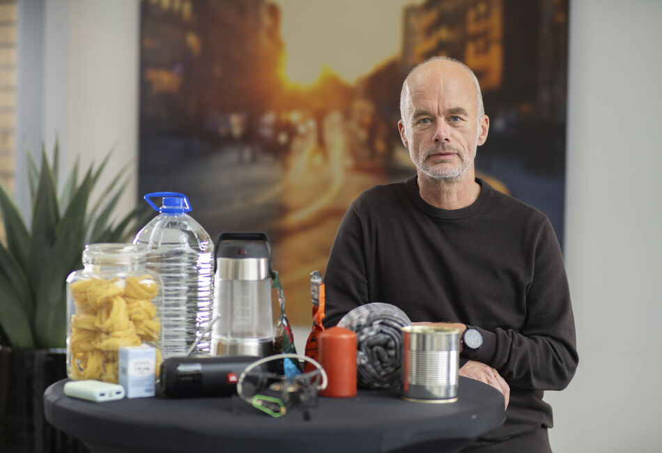 Tore Kamfjord viser frem vann, nødlader, hermetikk og andre varer som er viktige å ha i et beredskapslager.